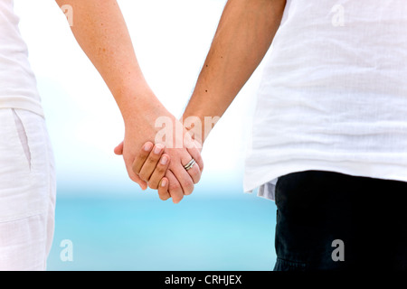 Couple holding hands par la mer dans un cadre romantique Banque D'Images