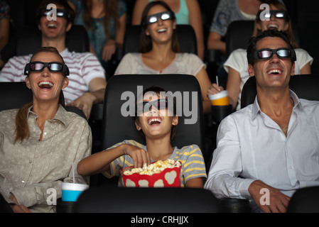 Family watching 3-D movie in theatre Banque D'Images