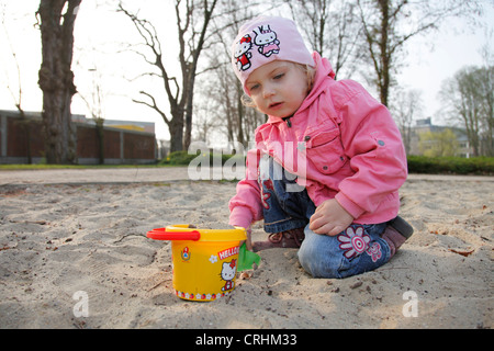 Fille avec des moules de sable à l'aire de jeux pour enfants Banque D'Images