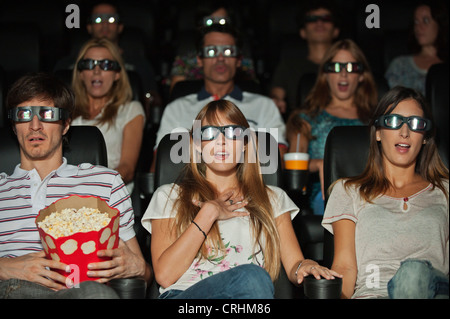 Audience portant lunettes 3-D au cinéma Banque D'Images