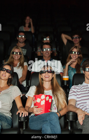 Audience portant lunettes 3-D au cinéma Banque D'Images