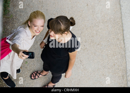 Les jeunes femmes posant pour téléphone cellulaire photo Banque D'Images