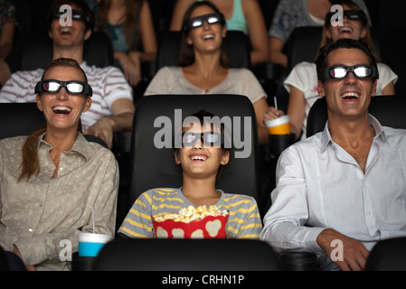 Family watching 3-D movie in theatre Banque D'Images