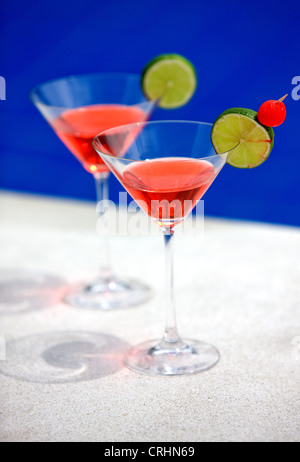 Des cocktails dans des verres à martini by a swimming pool Banque D'Images
