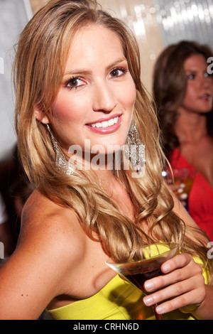 Happy smiling woman with cocktail dans un bar ou une discothèque Banque D'Images