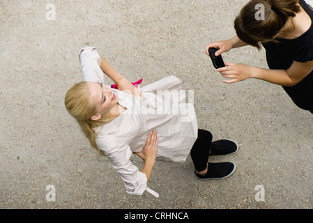 Young woman photographing ami avec téléphone cellulaire, elevated view Banque D'Images