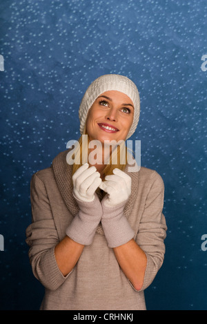 Woman wearing Knit hat et des gants en face de fond de neige, portrait Banque D'Images