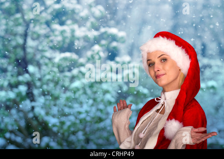 Woman wearing Santa hat, scène hiver en arrière-plan, Portrait Banque D'Images