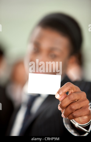 Businessman montrant une carte d'affaires dans un bureau Banque D'Images