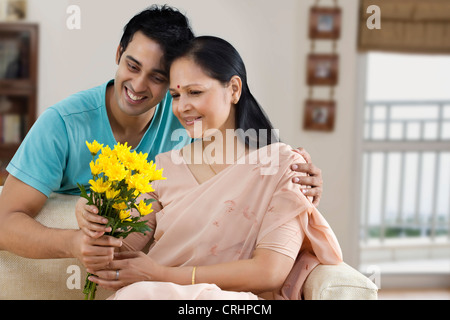 Jeune homme gifting bouquet de fleurs à sa mère Banque D'Images