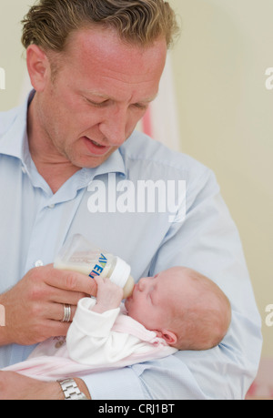 Père nourrir bébé avec du lait Banque D'Images