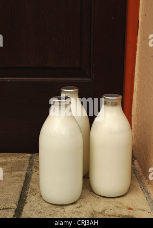 Bouteilles de lait sur une porte Banque D'Images