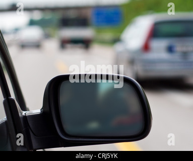 Rétroviseur d'une voiture roulant sur autoroute allemande. Banque D'Images