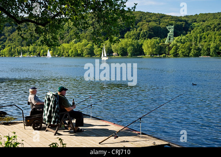 Deux pêcheurs assis sur une promenade au Lac Baldeney, ancienne mine de charbon Carl Funke en arrière-plan, l'Allemagne, en Rhénanie du Nord-Westphalie, région de la Ruhr, à Essen Banque D'Images