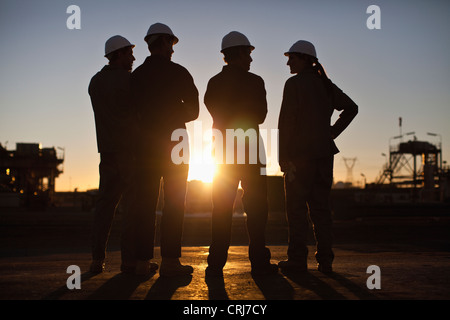 Silhouette d'ouvriers de la raffinerie de pétrole Banque D'Images