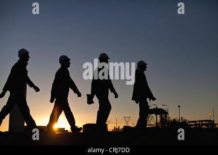 Silhouette d'ouvriers de la raffinerie de pétrole Banque D'Images