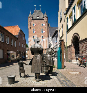 La sculpture de la femme à une pompe à eau dans la ville de Xanten, Gate Kleve, Klever Tor, dans l'arrière-plan, l'Allemagne, en Rhénanie du Nord-Westphalie, Xanten Banque D'Images