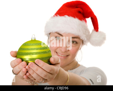 Belle jeune fille portant un chapeau de Noël à la recherche à un Christmas Tree ball Banque D'Images