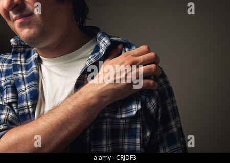 L'homme des jeunes adultes souffrant de douleur à l'épaule. Banque D'Images