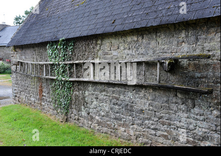 Sur des échelles en bois ancien bâtiment de ferme en pierre en Bretagne France Banque D'Images