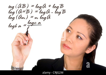Young Asian business woman writing un calcul mathématique sur la vitre devant elle avec un stylo Banque D'Images