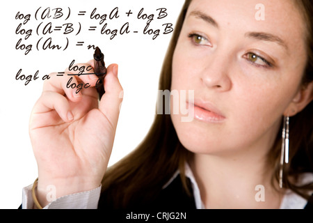 Jeune femme d'écrire un calcul mathématique sur la vitre devant elle avec un stylo Banque D'Images