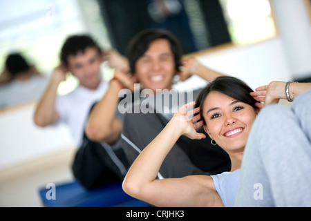 Groupe de personnes à la salle de sport un sourire faisant des exercices abs Banque D'Images