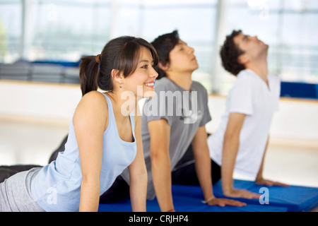 Les gens qui font des exercices d'étirement sur le sol dans la salle de sport Banque D'Images