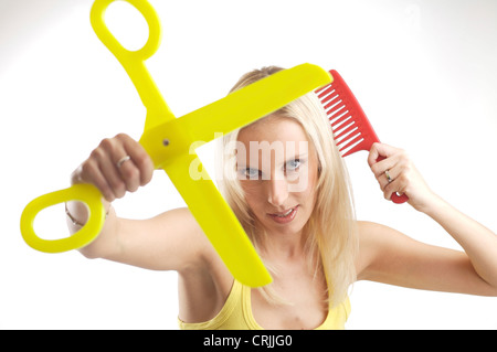 Jeune femme blonde avec des rayons et une paire de ciseaux Banque D'Images