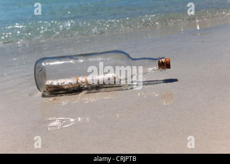 Message dans une bouteille sur la côte de sable Banque D'Images