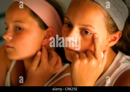 Deux filles contrôler leurs visages pour les taches. Banque D'Images