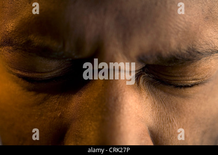 Un jeune homme tire ses yeux fermés. Banque D'Images