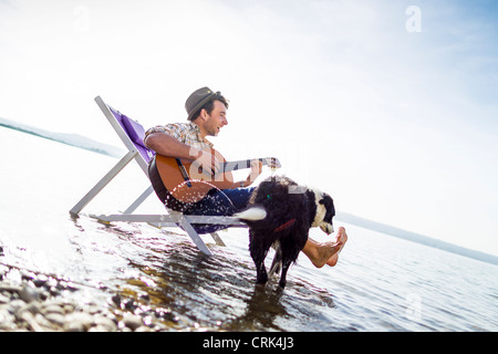 Man with dog in lawn chair in creek Banque D'Images