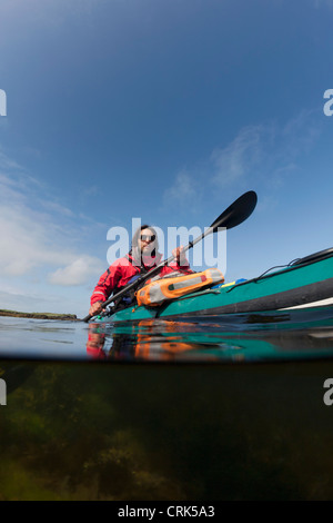 Homme kayak sur le lac encore Banque D'Images