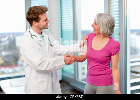 Womans shaking hand in office Banque D'Images