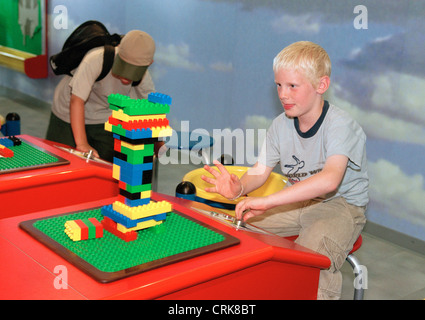 Les jeunes est en train de tester la stabilité de son tour à Legoland Banque D'Images