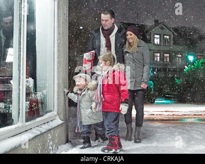 En admirant la famille dans la neige Noël fenêtre Banque D'Images