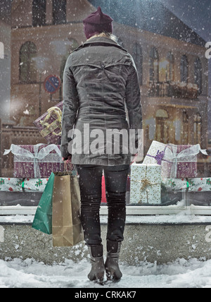 Woman carrying shopping bags in snow