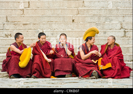 Moines bouddhistes tibétains (Geluk ou jaune Hat) à l'extérieur de la Sutra du Grand Hall du monastère de Labrang avant d'aller à la prière. Banque D'Images