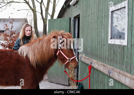 Woman feeding horse en plein air Banque D'Images