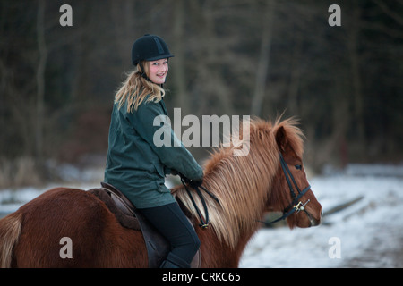 Woman riding horse in snow Banque D'Images