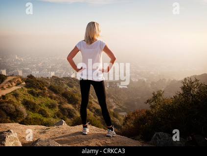 Femme donnant sur vue depuis une colline Banque D'Images