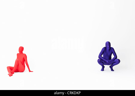 Couple in bodysuits sitting on floor Banque D'Images