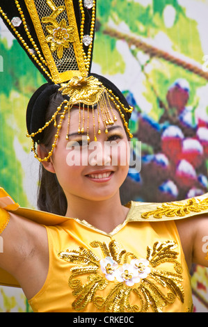 Une jeune chinoise locale habillés en vêtements traditionnels d'effectuer sur une street parade dans le centre de Dunhuang. Banque D'Images