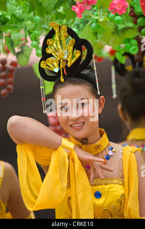 Une jeune chinoise locale habillés en vêtements traditionnels d'effectuer sur une street parade dans le centre de Dunhuang. Banque D'Images