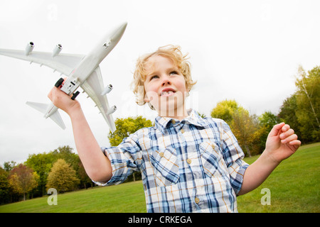 Boy Playing with toy airplane outdoors Banque D'Images