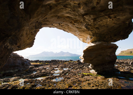 Une grotte marine près de la baie de Liag à Cleadale sur l'île de Eigg, à l'égard de l'île de Rum, Ecosse, Royaume-Uni. Banque D'Images