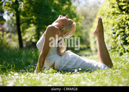 Une jeune femme pratiquant le yoga à l'extérieur Banque D'Images