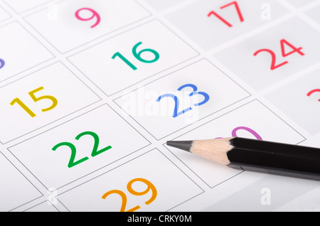 Crayon noir sur la page de calendrier avec des dates Banque D'Images