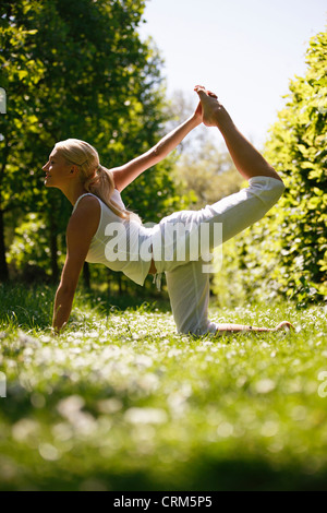 Une jeune femme pratiquant le yoga à l'extérieur Banque D'Images